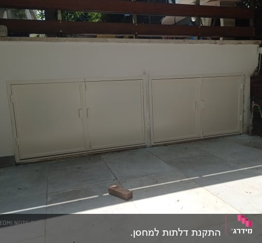 שלוש דלתות מתכת לבנות עם מסגרות על קיר חיצוני